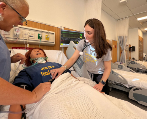 Hanna Johnson works on a patient in the simulation lab alongside Assistant Professor of Nursing, Julie Briere, MSN.