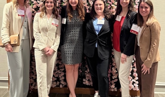 Photo of six women dressed professionally, looking at the camera smiling in front of a background that says, "Washington-Marriott Georgetown."
