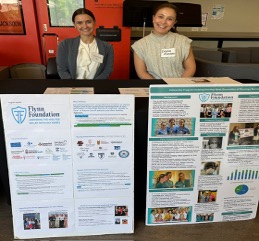 Two students sit at a table at the 16th Edith Richner Annual Palliative Care Conference at Molloy University